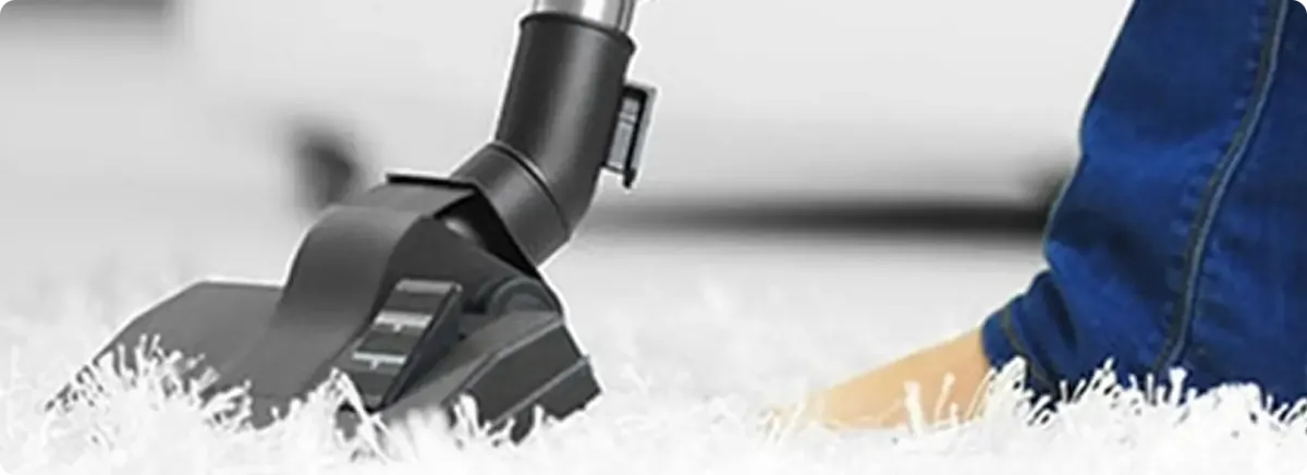 Close-up of a professional vacuuming a white carpet in Orange Park.